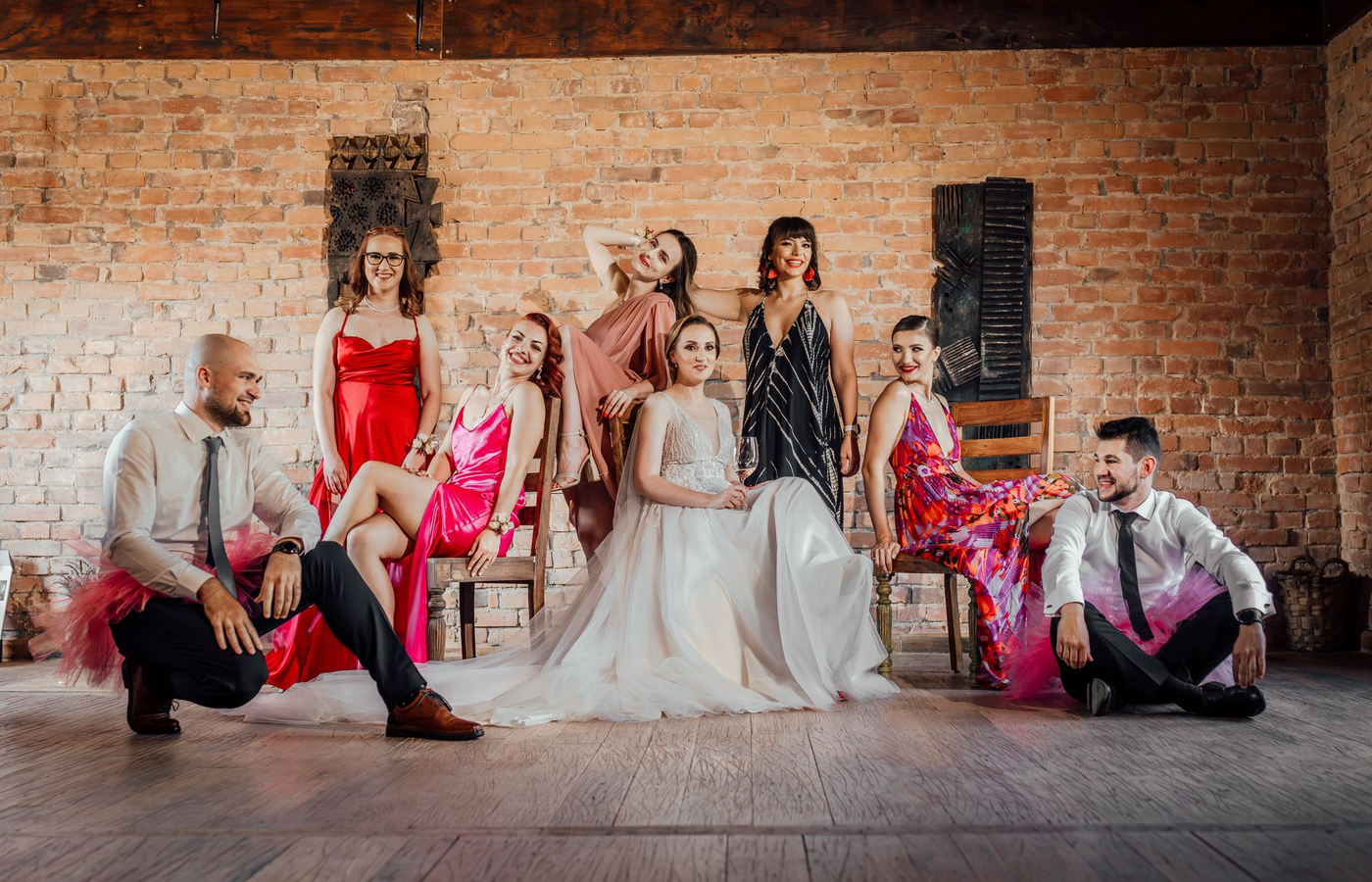 Event hosts in formal dress standing beside a dressed event table before guests arrive