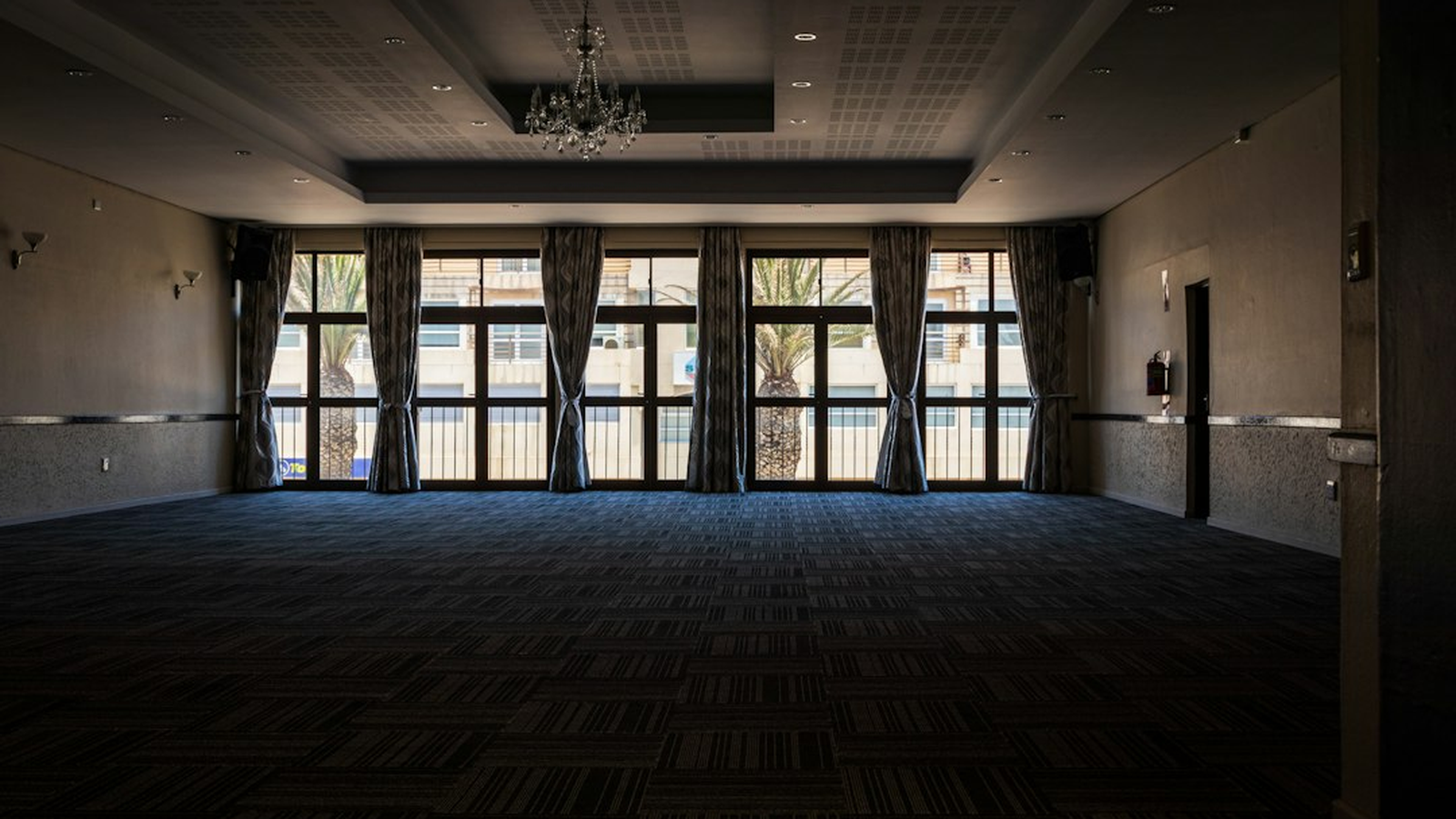 Wide view of a function room laid out with several hosted casino-themed event tables before guests arrive