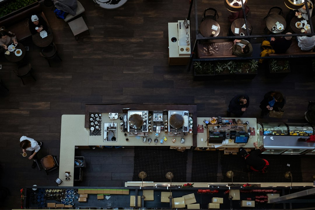 Printed venue floor plan on a desk with table positions marked, beside a notebook and pen