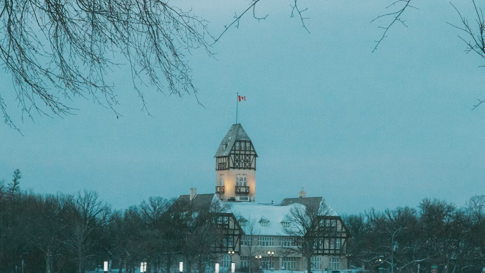 Warmly lit venue windows on a northern Manitoba winter evening with snow in the foreground