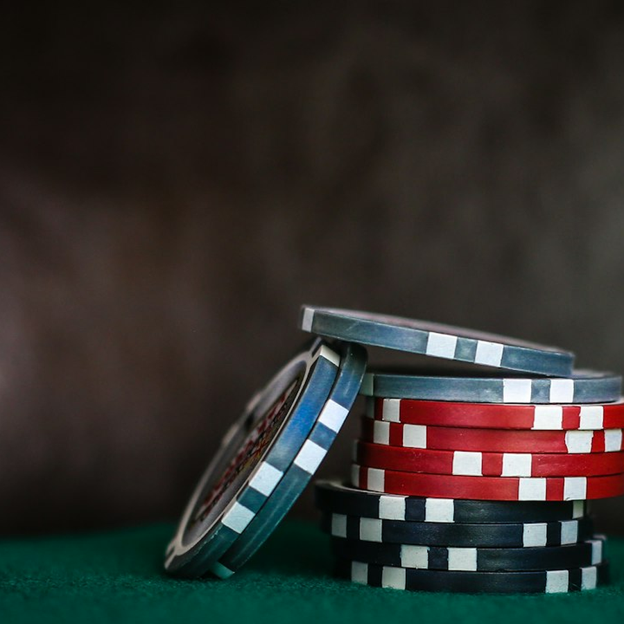 Stack of plain unmarked symbolic event chips in champagne and slate tones
