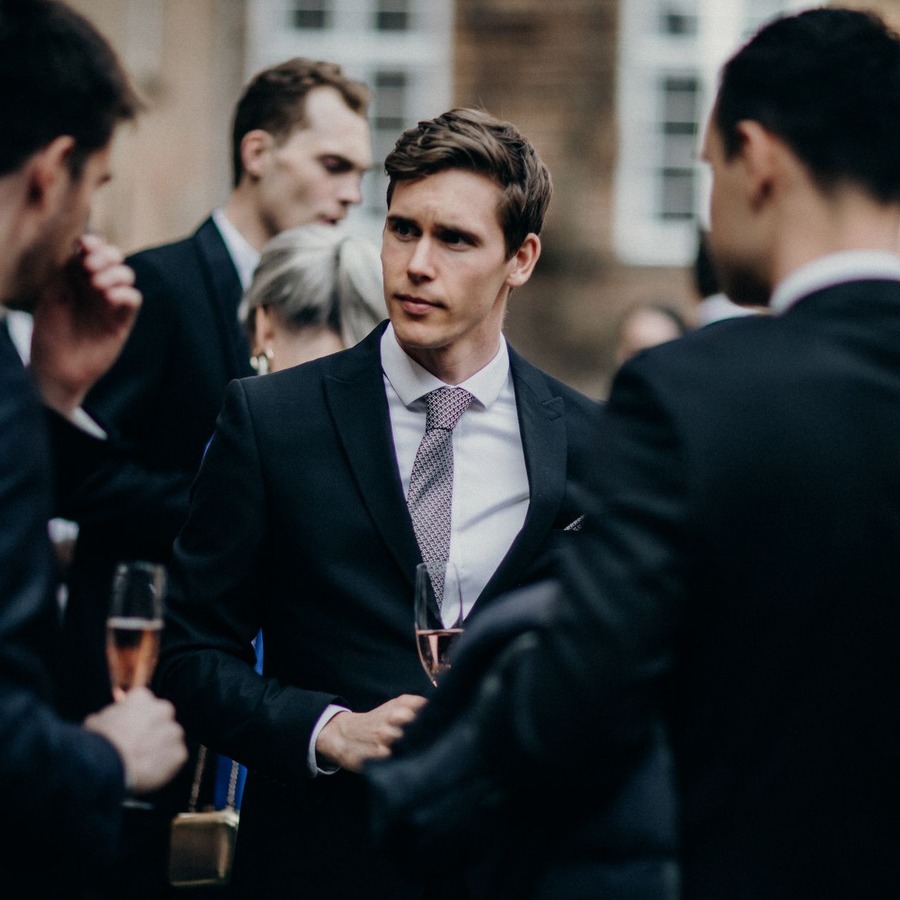 Adult guests in formal dress raising glasses in a softly lit event lounge